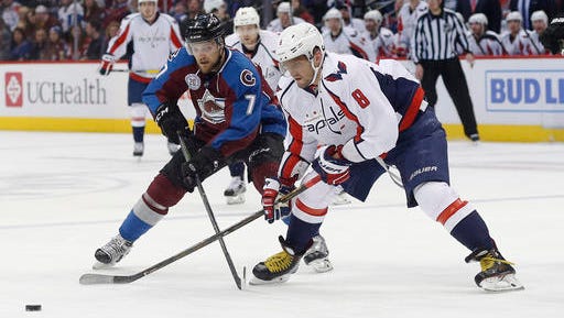 Colorado Avalanche center John Mitchell, left, and Washington Capitals left wing Alex Ovechkin, of Russia, compete for the puck during the third period of an NHL hockey game Friday, April 1, 2016, in Denver. Washington won 4-2. (AP Photo/David Zalubowski)