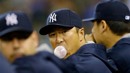 New York Yankees pitcher Hiroki Kuroda blows a bubble as he stands in the dugout during a baseball game against the Seattle Mariners, Thursday, June 12, 2014 in Seattle.