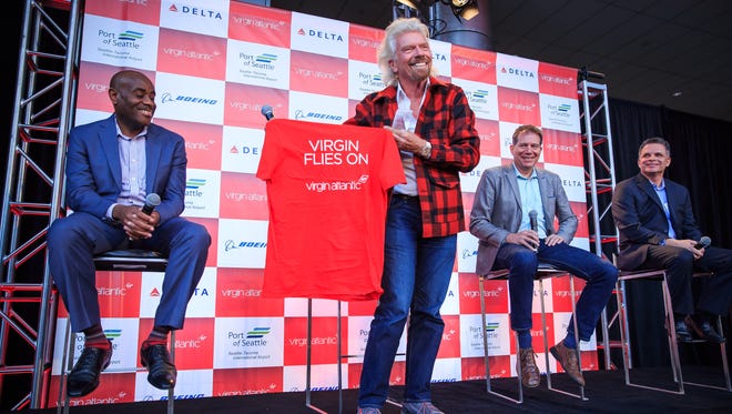 Virgin Atlantic founder Richard Branson holds up a shirt suggesting the Virgin name will live on, likely a reference to Alaska Air’s decision to end the name of merger partner Virgin America. Perhaps not coincidentally, Virgin Atlantic is now 49% owned by Alaska Air rival Delta.