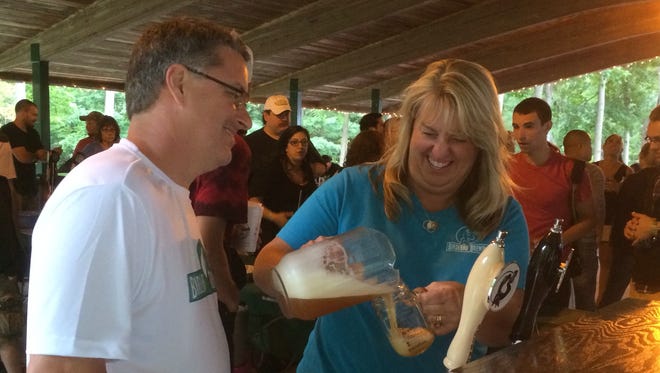Dennis Edwards and his wife, Susan, from Horseheads, pour samples of their craft beer at Zoo Brew on Saturday at the Binghamton Zoo at Ross Park.