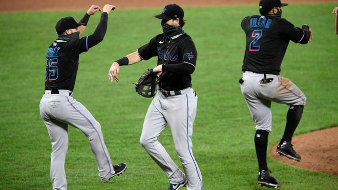 Miami Marlins' Brian Anderson, center, Eddy Alvarez, left, and Jonathan Villar (2) celebrate after a baseball game against the Baltimore Orioles, Thursday, Aug. 6, 2020, in Baltimore.