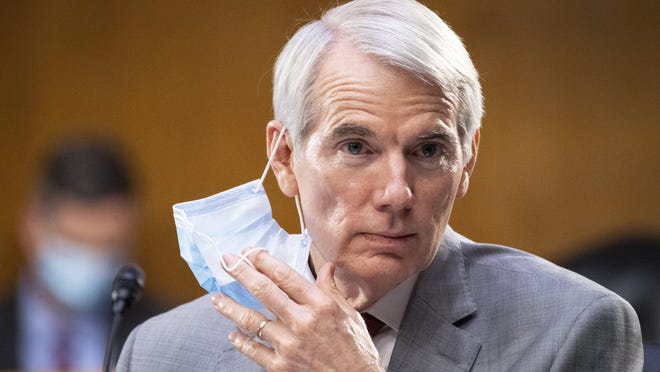 Sen. Rob Portman, R-Ohio, takes off a mask during a Senate Finance Committee hearing on "COVID-19/Unemployment Insurance" on Capitol Hill in Washington on Tuesday, June 9, 2020.