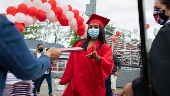 Dafne Martinez, a graduating senior at Burlington High School, receives her diploma before walking across the stage during the Class of 2020 graduation ceremony, June 7, 2020.
