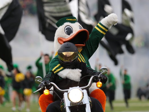 The Oregon Ducks mascot rides on the back of a motorcycle