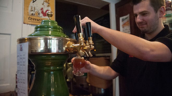 Nick Mariano pours an IPA at Village Idiot Brewing in Mount Holly, a town is in the midst of a beer revolution.
