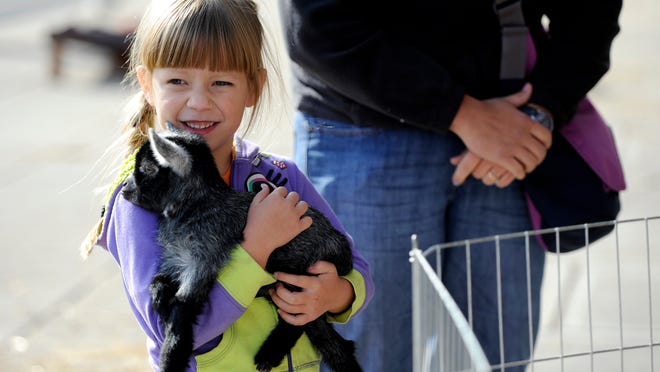 
Lydia Beery, 6, of Frankfort, and a member of the Cloverbuds, holds a 2-week-old pygmy goat with her mom, Sadie Beery. A celebration for the 100th anniversary of the Ohio State University Extension was hosted Saturday at the Ross County Service Center. Visitors were able to tailgate, visit a petting zoo, make crafts and learn about 4-H programs and activities.
