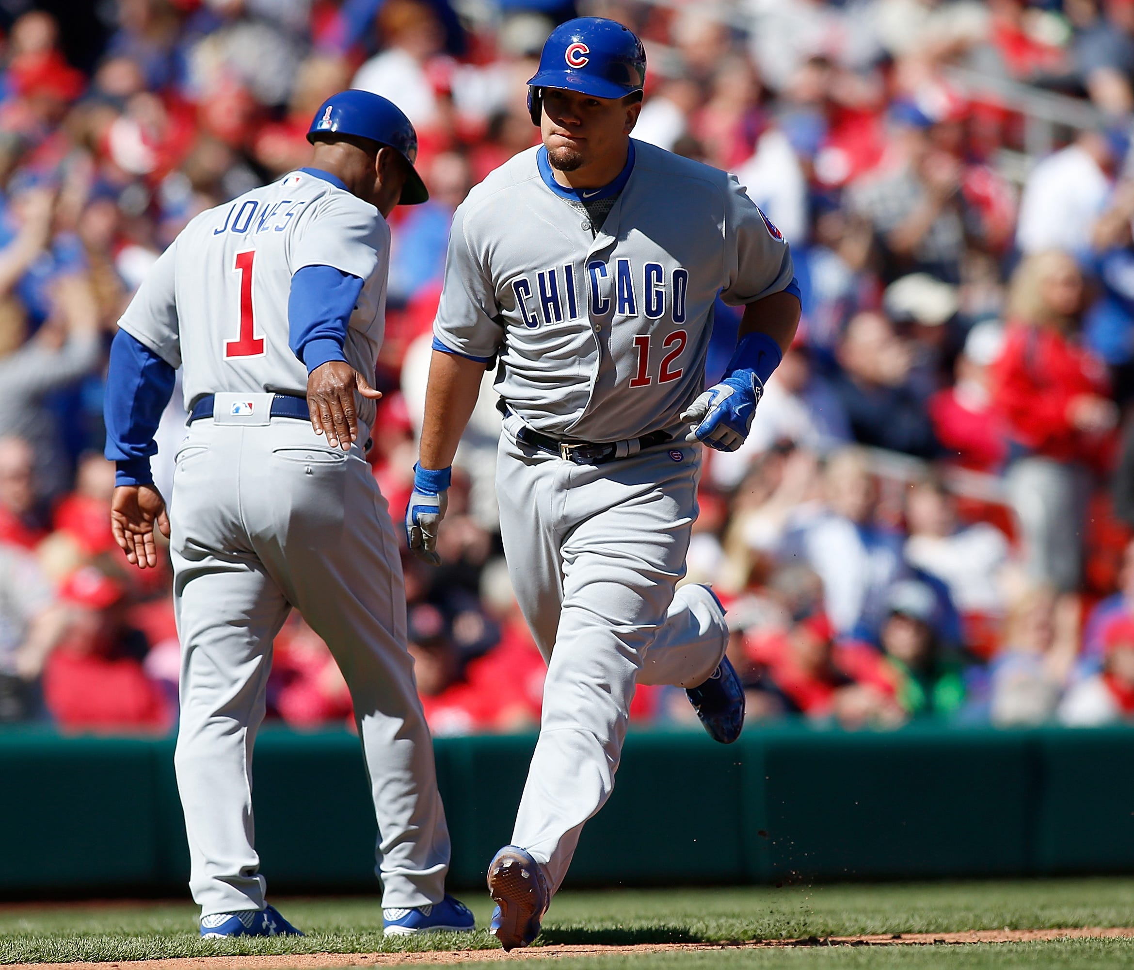 Kyle Schwarber is congratulated by third base coach Gary Jones after hitting a three run home run.