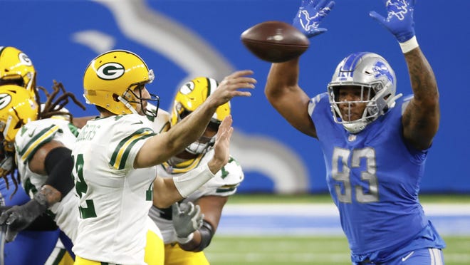 Detroit Lions defensive end Da'Shawn Hand (93) rushes-on Green Bay Packers quarterback Aaron Rodgers (12) as he passes in the second half during an NFL football game, Sunday, Dec. 13, 2020, in Detroit.
