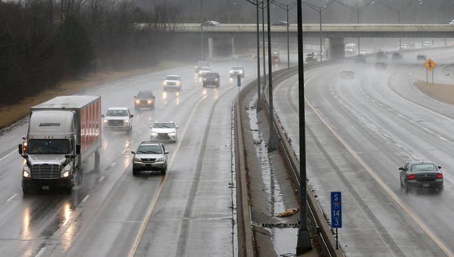 Vehicles travel along Interstate 71 in Blue Ash as rain and freezing rain fall, Friday, Jan. 12, 2018.