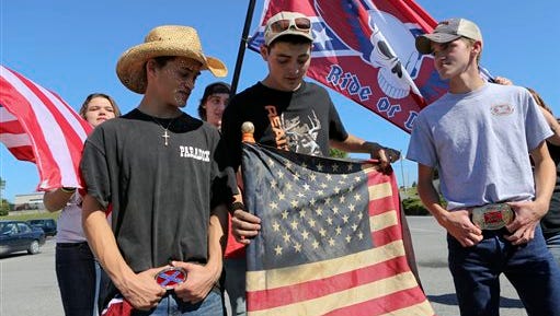 Christiansburg High School students bearing American and Confederate flags gather in a shopping center parking lot after being suspended from school property in Christiansburg, Va. Thursday, Sept. 17, 2015. Roughly 20 students at the Virginia high school received a one-day suspension for wearing clothing displaying the Confederate flag. A rally was also organized outside the school Thursday to protest a new school policy banning vehicles with Confederate symbols from its parking lot. (Matt Gentry /The Roanoke Times via AP) LOCAL TELEVISION OUT; SALEM TIMES REGISTER OUT; FINCASTLE HERALD OUT;  CHRISTIANBURG NEWS MESSENGER OUT; RADFORD NEWS JOURNAL OUT; ROANOKE STAR SENTINEL OUT; MANDATORY CREDIT