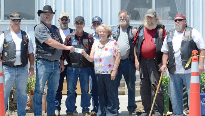Randy LaBelle, second from left, president of the Over the Hill Motorcycle Club, presents a donation check last week to Kathy McIntosh, center, director of the Silver Springs Food Pantry. Also pictured, from left, are club members Rich Wilson, Charles Moore, Jim Miller, Bob Clark, Troy Forcier, Griz Schragl and Phil Hilliard.