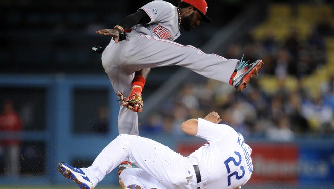 Los Angeles Dodgers starting pitcher Clayton Kershaw (22) slides under Cincinnati Reds second baseman Brandon Phillips (4) to reach second on a wild pitch in the fifth inning at Dodger Stadium.