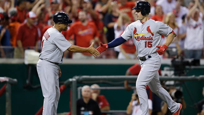 St. Louis Cardinals' Randal Grichuk (15) celebrates with third base coach Jose Oquendo, left, as he rounds the bases on a solo home run off Cincinnati Reds starting pitcher Dylan Axelrod in the 13th inning of a baseball game, Wednesday, Aug. 5, 2015, in Cincinnati. The Cardinals won 4-3. (AP Photo/John Minchillo)