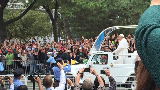 Pope Francis greets onlookers upon his arrival at the papal Mass.