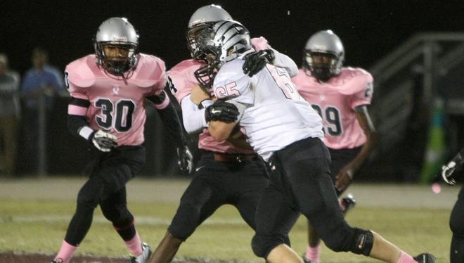 A Liberty player wraps up South Side's Jordan Taylor in a 49-6 Crusader win Friday.