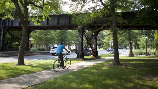 A bicyclist rides under the CSX bridge on North Main Street in Pittsford.