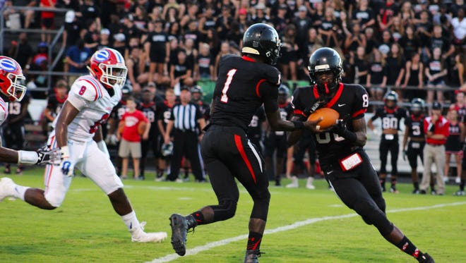 Parkway quarterback Justin Rogers hands the ball off in a game against Evangel earlier this season.