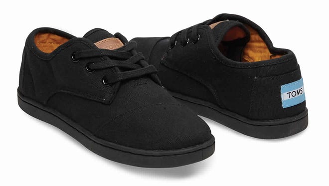 A pair of Toms black canvas shoes.
