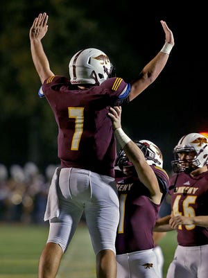 After scoring his team's first touchdown, Ankeny quarterback #7 Cole Whitaker, left, leapt in the air as he celebrated with #11 Jacob Morrissey against Southeast Polk in game at Ankeny Stadium on Friday night Oct. 24, 2014.