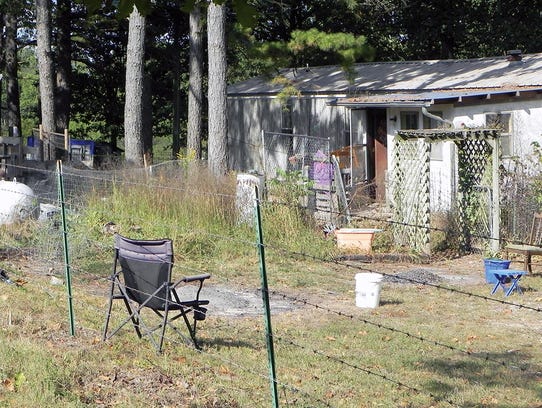 A pair of small burn piles sit behind a residence on