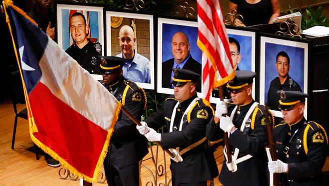 The Dallas Police color guard presents the colors before the photos of five fallen officers being remembered during an interfaith memorial service at the Morton H. Meyerson Symphony Center in Dallas, Tuesday, July 12, 2016. Four Dallas police officers and one Dallas Area Rapid Transit (DART) officer were gunned down last week in downtown Dallas at a protest rally. The victims are depicted, from left, Dallas PD officer Michael Krol, DART officer Brent Thompson, Dallas police Sr. Cpl. Lorne Ahrens, Dallas police Sgt. Michael Smith, and Dallas police Officer Patrick Zamarripa.