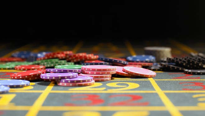 Various gambling chips on roulette table.