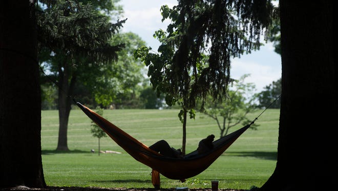 Amanda Magnusson enjoys the shade as she sits in her hammock at City Park on May 30.