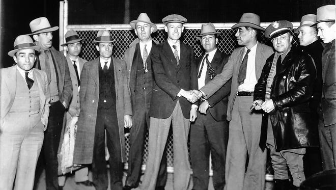 Jeff Meers and Jose Carrasco shake hands at the international boundary at the middle of the Santa Fe Street Bridge in the early morning hours of April 20, 1933. The two prisoners were exchanged by authorities from the United States and Mexico.