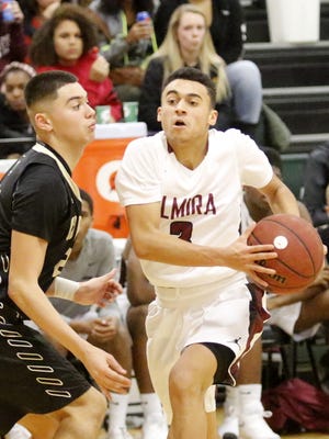 Elmira's Quinton Ellis drives toward the basket as Corning's Jason Rodriguez defends during a boys basketball game at Elmira High School.