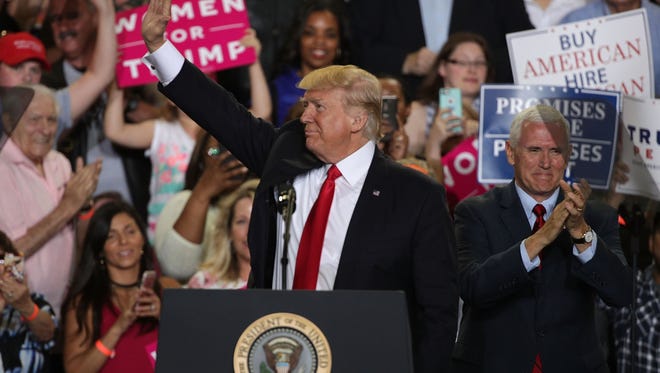 U.S. President Donald Trump (L) acknowledges supporters as Vice President Mike Pence (R) looks on during a "Make America Great Again Rally" at the Pennsylvania Farm Show Complex & Expo Center April 29, 2017 in Harrisburg, Pennsylvania. President Trump held a rally to mark his first 100 days of his presidency.