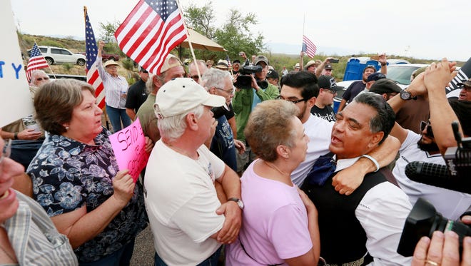 Immigration activists face off during a protest in Oracle, Ariz., on July 15, 2014. About 300 protesters lined the road waiting for a busload of illegal immigrants.