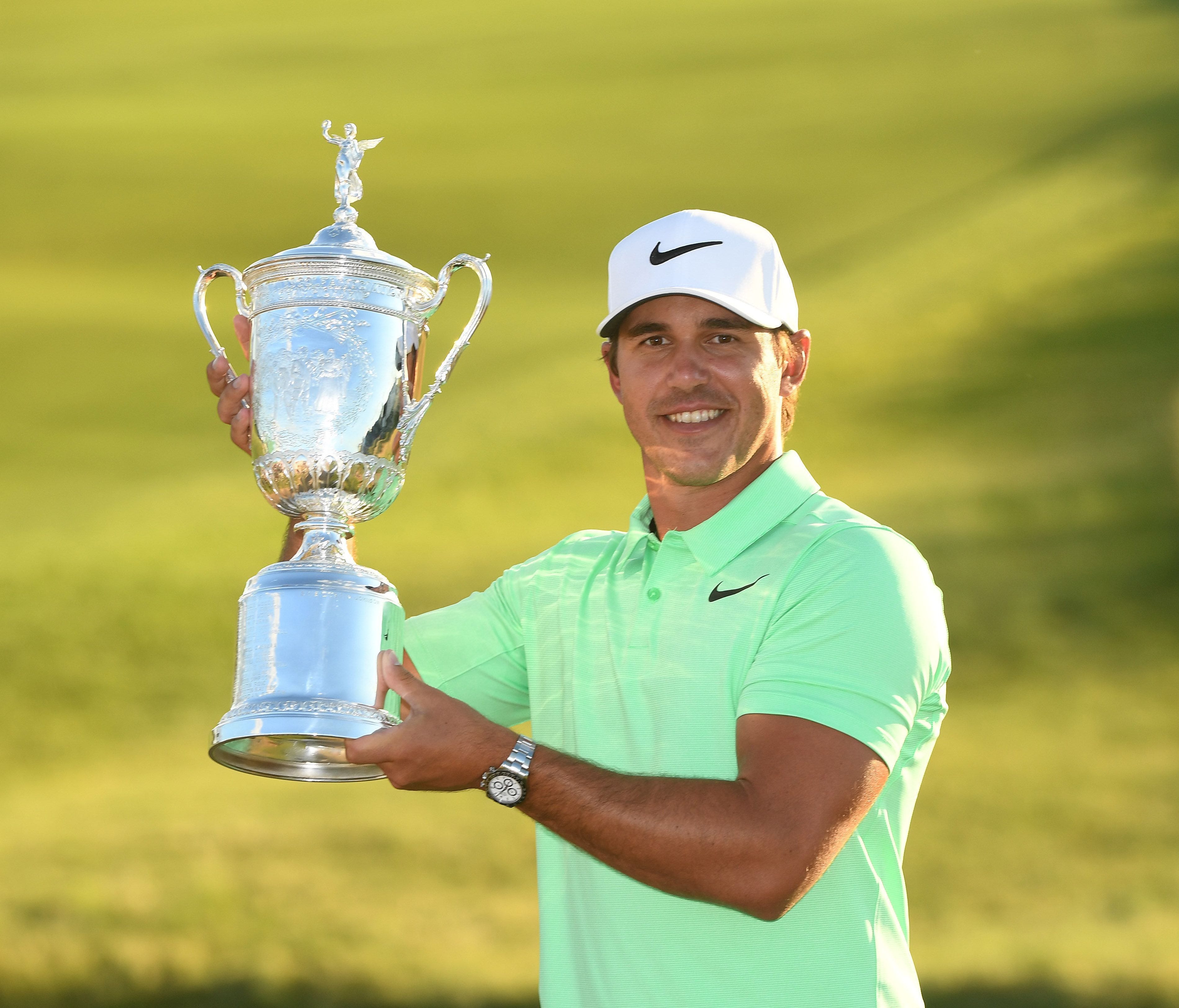 Brooks Koepka poses with the trophy after winning the U.S. Open golf tournament at Erin Hills on June 18.