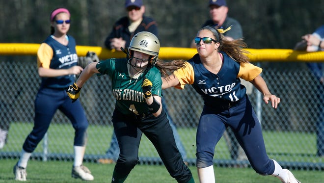 Rush-Henrietta's Marissa Hedding is caught in a pickle and tagged on her way back to second base from first by Victor's Kara Commisso in the fourth inning at Rush-Henrietta High School.