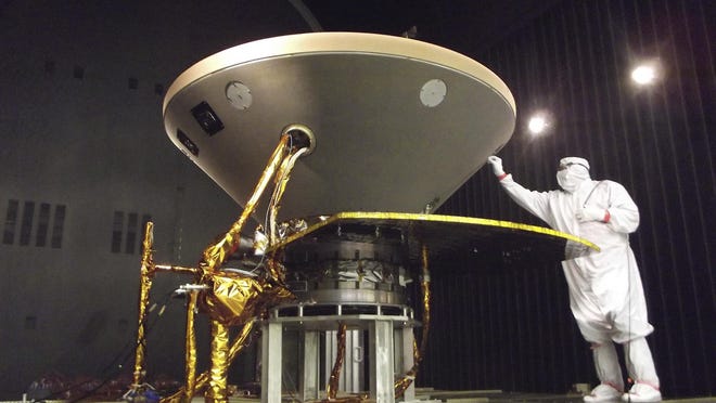 In this 2015 photo made available by NASA, a technician prepares the InSight spacecraft for thermal vacuum testing in its "cruise" configuration for its flight to Mars, simulating the conditions of outer space at Lockheed Martin Space Systems in Denver. NASAâs three-legged, one-armed geologist known as InSight makes its grand entrance through the rose-tinted Martian skies on Monday, Nov. 26, 2018. (NASA/JPL-Caltech/Lockheed Martin via AP)
