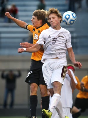 Brebeuf's Robby Morelock , front, heads the ball as he goes up against Jordan Kleyn of Avon, as Ryan Delaney looks on, in the Braves' 1-0 win over Avon in their boys soccer regional semifinal game at North Central High School in Indianapolis on Thursday, October 16, 2014. Brebeuf will play the winner of the Westfield-Cathedral game that followed.