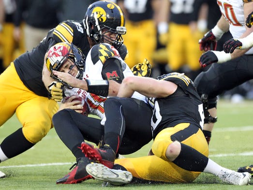 Iowa's Nathan Bazata, left, and parker Hesse tackle