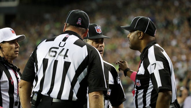 Officials, including side judge Keith Washington, right, discuss a play late in the fourth quarter between the Seattle Seahawks and the Detroit Lions.