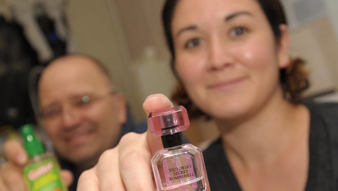 NMSU biology professor Immo Hansen, left, and research assistant Stacy Rodriguez display household products they tested to measure mosquito repellent effectiveness. Cutter brand repellents as well as Victoria's Secret Bombshell perfume, right, were among some of the products they tested.