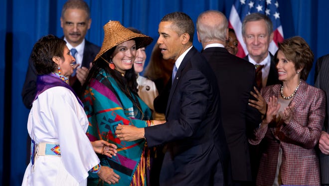 President Obama greets Our Sister's Keeper executive director Diane Millich, from left, and Tulalip Tribes of Washington State vice chairwoman Deborah Parker, after signing the Violence Against Women Act , March 7, 2013, at the Interior Department in Washington.