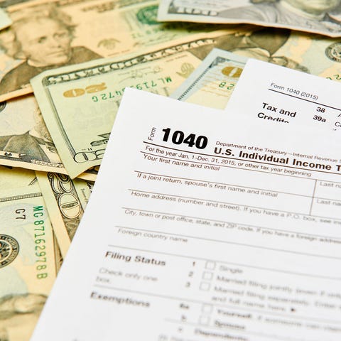 Tax Form 1040 on a pile of money