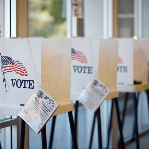 A row of partitioned voting booths with attached p