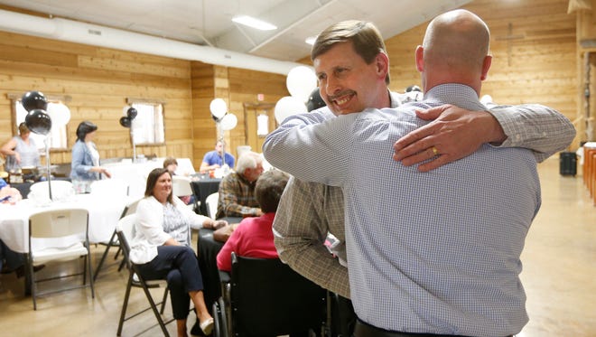 Willard assistant superintendent Stewart Pratt hugs Chip Arnette during a surprise  party at the Sac River Cowboy Church on Thursday, May 5, 2017.