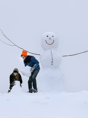 Chasing away the winter blues can be as simple as building a snowman for passers-by to enjoy.