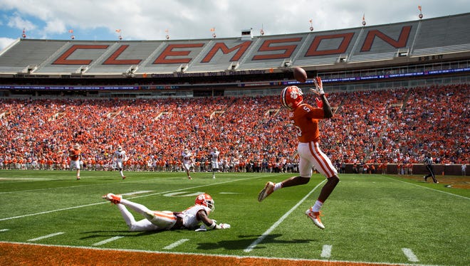 Clemson wide receiver Tee Higgins (5) evades cornerback Mark Fields (2) to catch the ball and score a touchdown during the 2018 spring football game on Saturday, April 14, 2018.