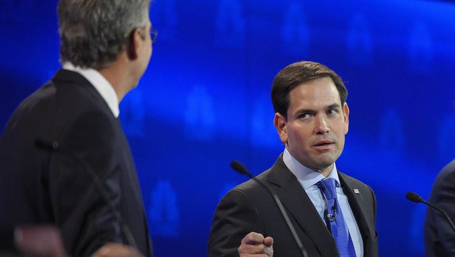 Marco Rubio, right, and Jeb Bush argue a point during the CNBC Republican presidential debate at the University of Colorado, Wednesday in Boulder, Colo.
