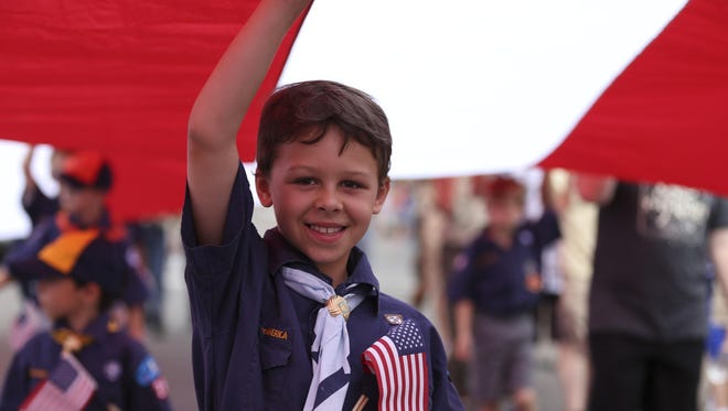 Garret Ruffini helps carry the American flag during the parade in downtown Great Falls last year.