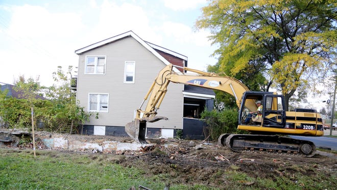 Jason Danneels, an operator engineer, helps pull down houses in the 1500 block of Alter in Detroit Wed., Oct. 7, 2015. A total of ten homes are being taken down erasing eyesores that have plagued the neighborhood for years.
