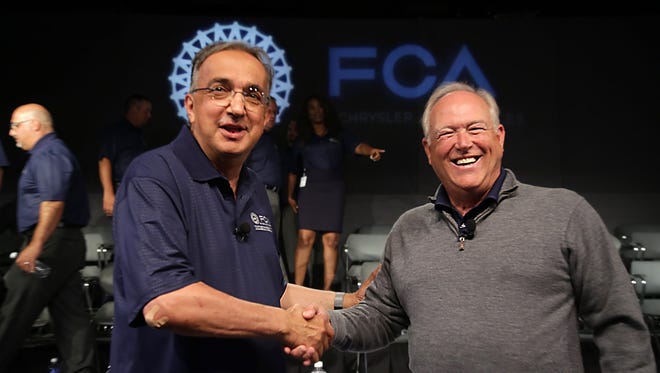Fiat Chrysler CEO Sergio Marchionne, left, shakes hands with UAW President Dennis Williams, during an event to mark the ceremonial beginning of its contract talks  at the UAW-Chrysler National Training Center in Detroit on Tuesday, July 14, 2015.