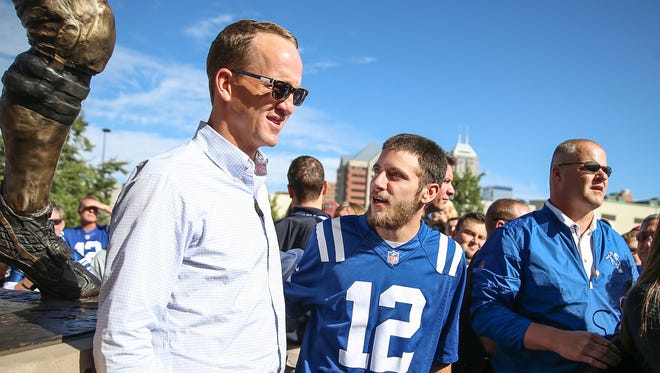 Peyton Manning poses for photos with fans in front of his statue, before the Colts' game against the San Francisco 49ers at Lucas Oil Stadium, Sunday, Oct. 8, 2017.
