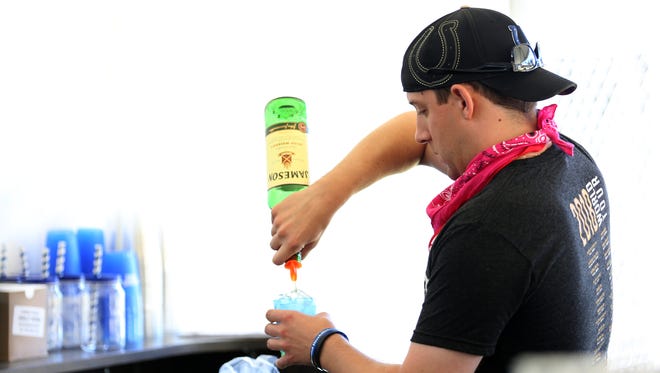 Jake Atwell-Scrivner serves a whiskey and cola during Cherryfest NW at Riverfront Park in Salem on Saturday, July 7, 2018. This is the first big event held at a public park since the city's new hard alcohol ordinance has gone into effect.